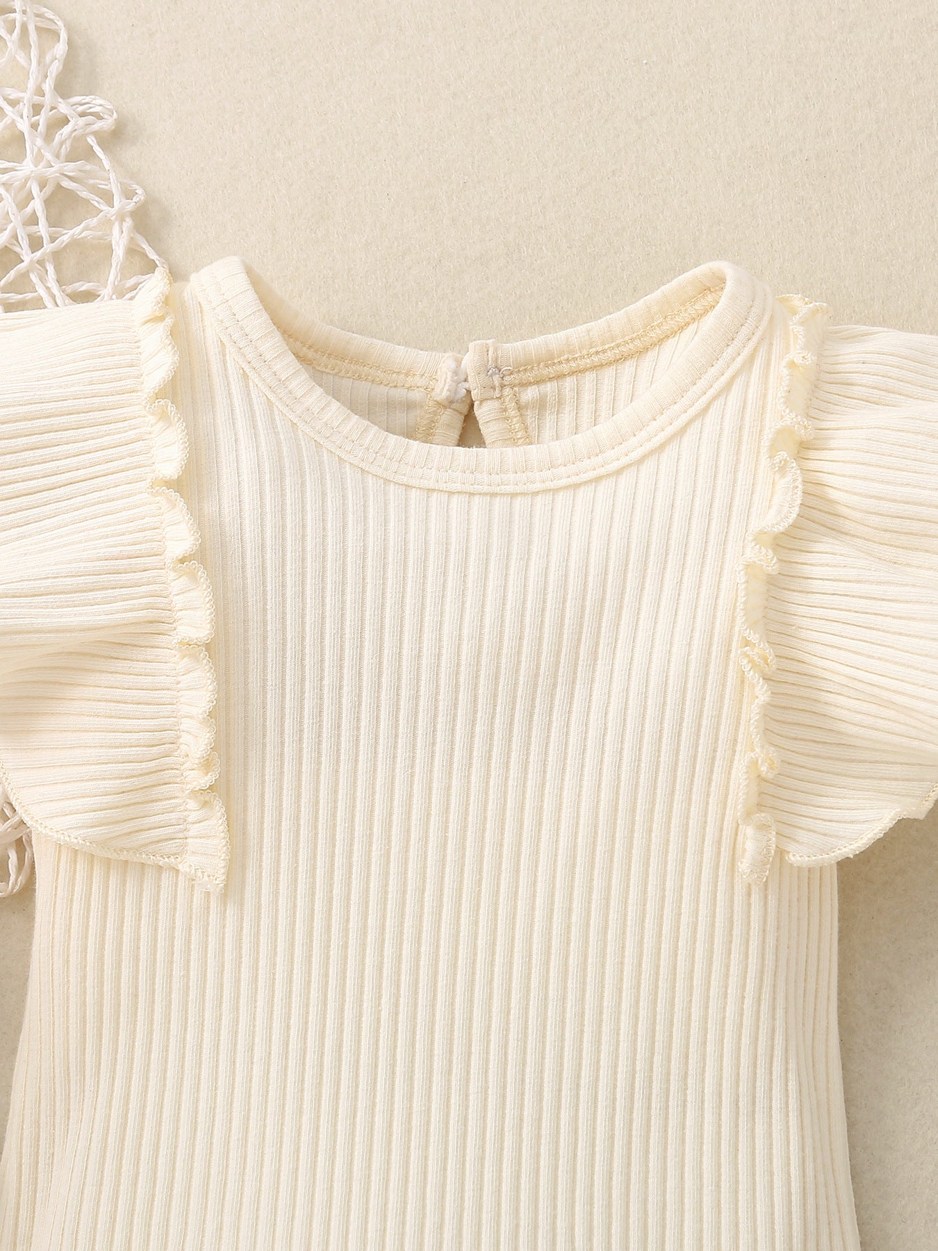 Ribbed baby set in cream with ruffled cap sleeves and a keyhole back detail.