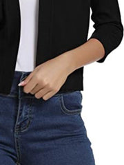 Black cropped knit cardigan with elbow sleeves and open front, styled with jeans.