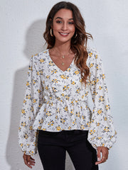 White floral peplum blouse with V-neck, gathered waist, and balloon sleeves.