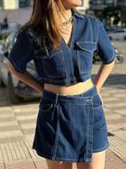 Dark blue denim cropped utility shirt and asymmetric skort set with white stitching.