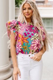 Floral ruffle sleeve silk blouse with bright floral print and pink trim.