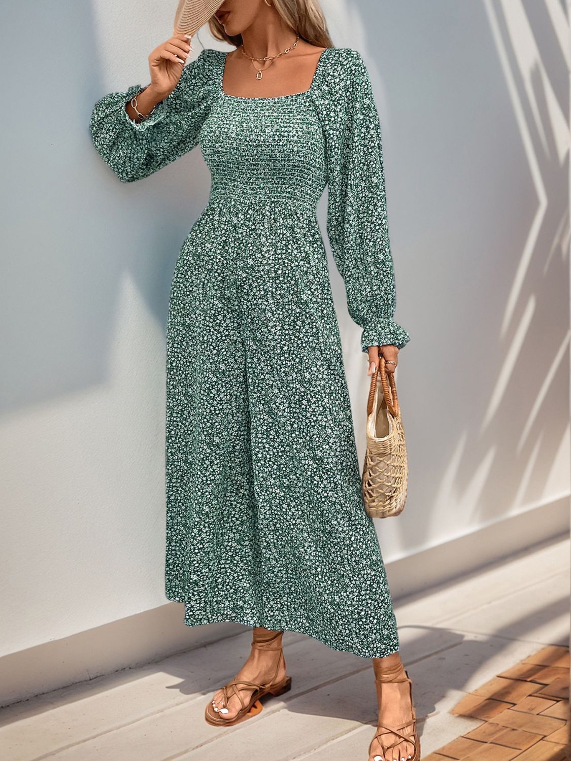 Turquoise floral jumpsuit with square neck, smocked waist, and long sleeves.