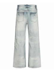 Men's light blue vintage wash wide leg jeans with distressed details.