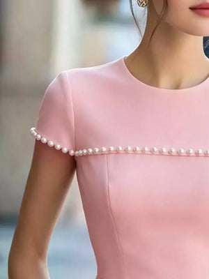 Dusty pink peplum t-shirt with pearl trim on sleeves and neckline.