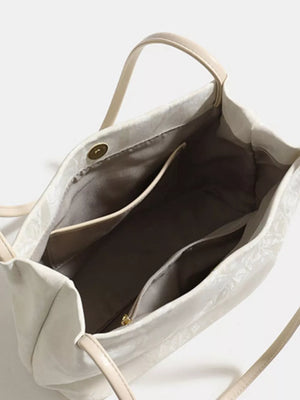 White pu leather shoulder bag with interior pockets and gold-tone snap closure.