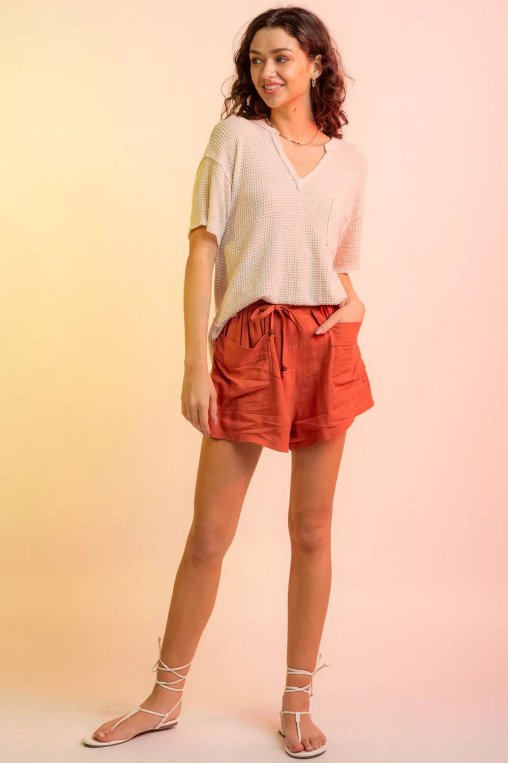 Relaxed waffle knit V-neck top in pale blush with short sleeves and a chest pocket.