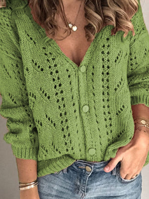 Green knit cardigan with chevron pattern and button-down front, featuring a V-neck and open knit details.