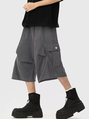 Relaxed fit dark gray cargo sweatpants with cropped length and buttoned flap pockets.