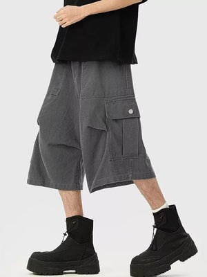 Relaxed fit dark gray cargo sweatpants with cropped length and buttoned flap pockets.