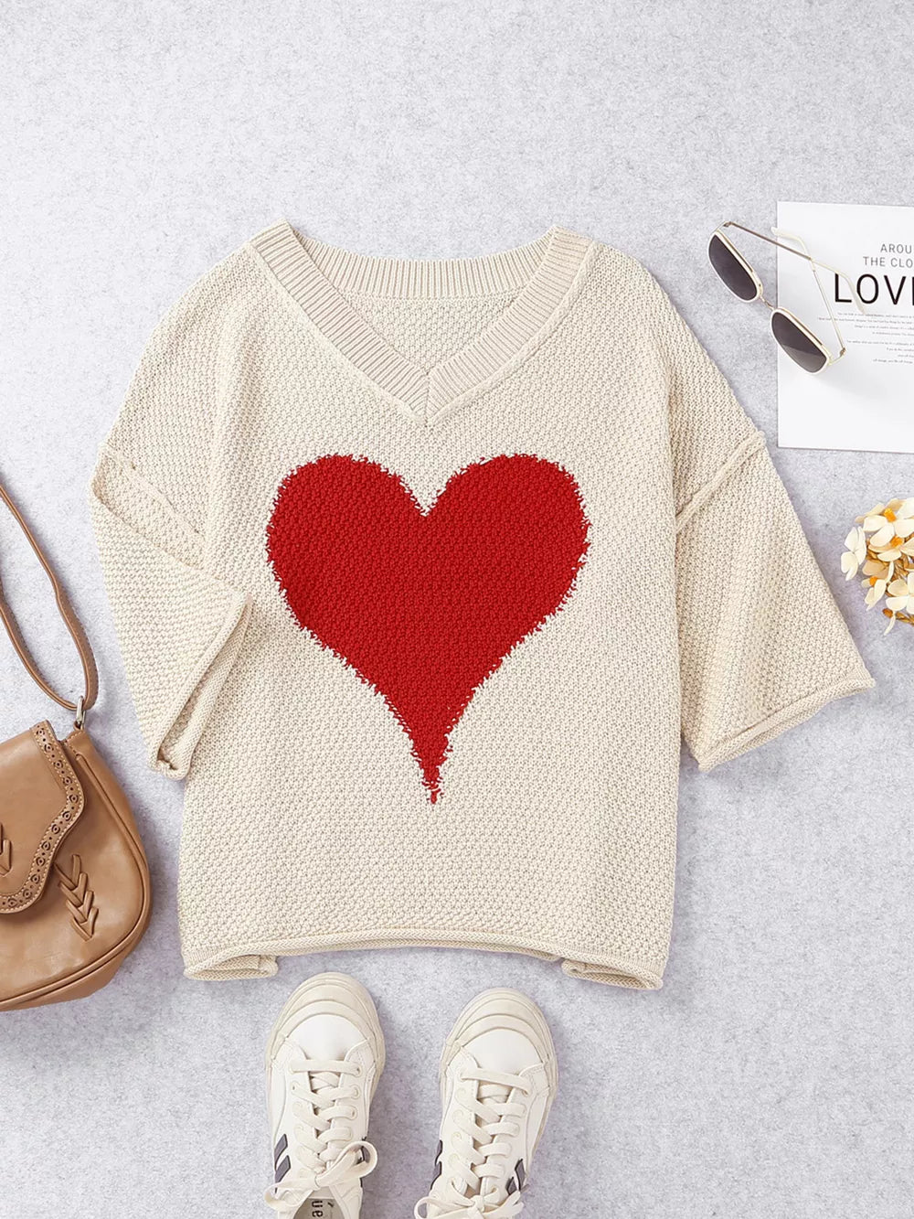 Beige V-neck knit sweater with a large red heart pattern, short sleeves, and textured knit.