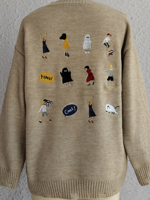 Tan knit sweater with embroidered characters and speech bubbles.