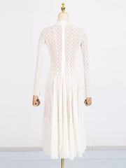 White lace maxi dress with mock neck, long sleeves, and a full skirt.