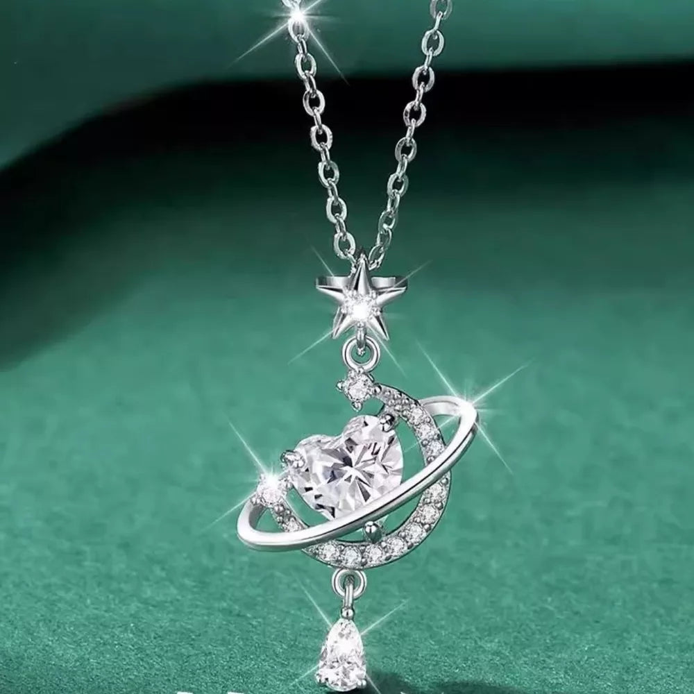 Silver celestial heart pendant necklace with star and planet ring, adorned with clear crystals.