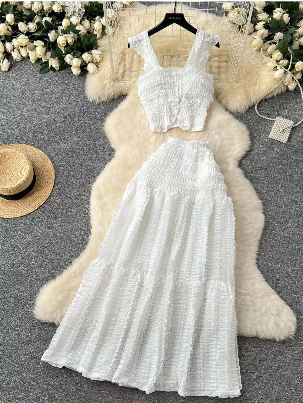 White textured two-piece set with ruffled crop top and tiered skirt.