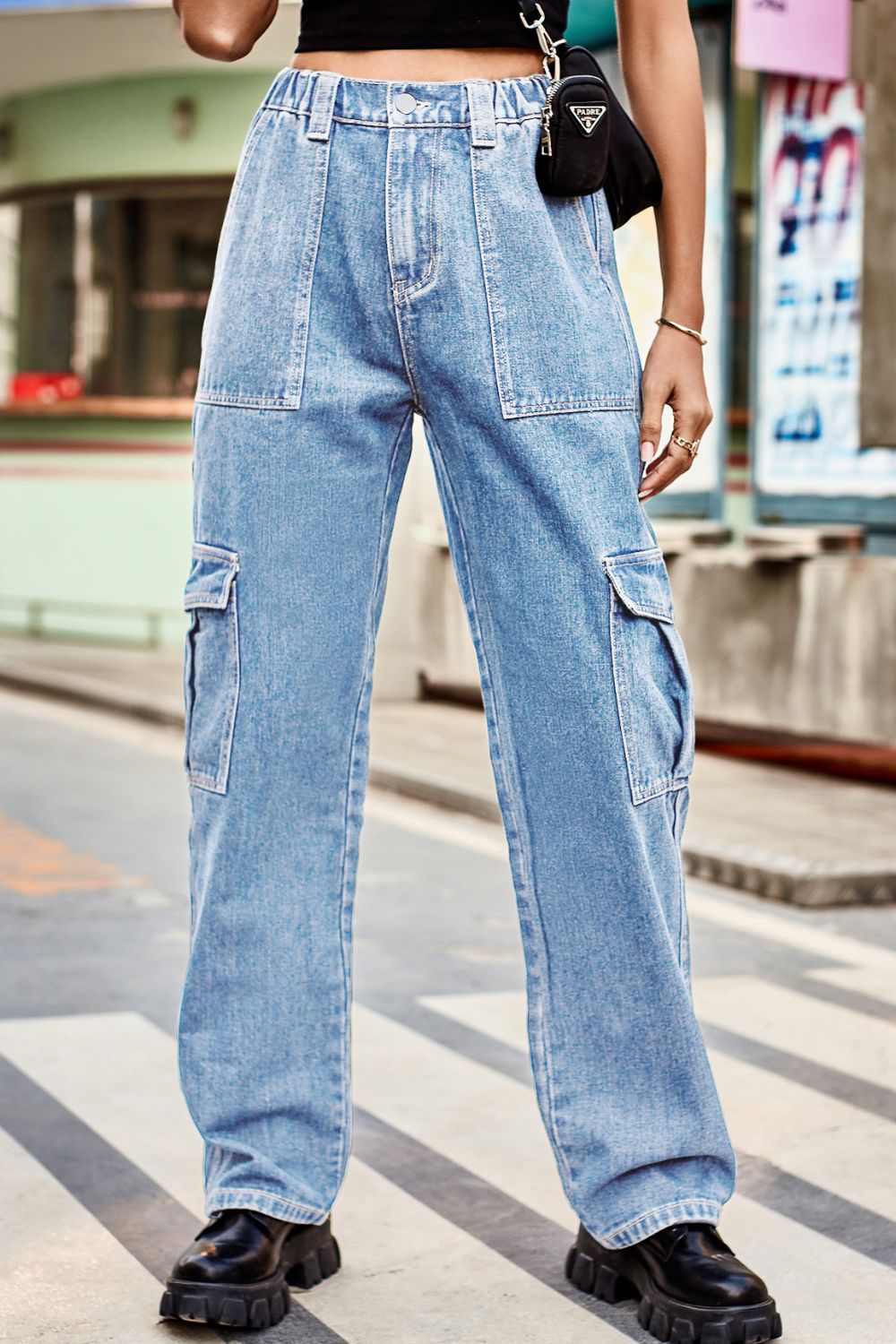 Light wash denim cargo pants with relaxed fit and multiple pockets.