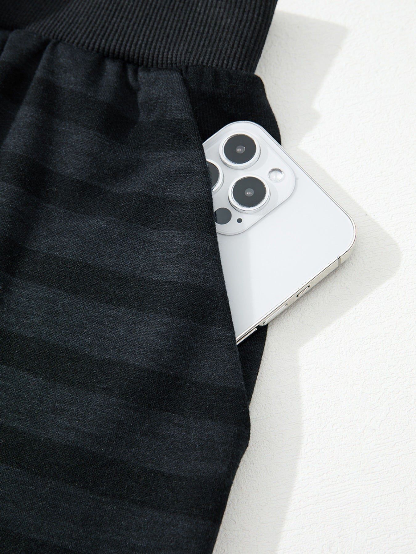 Dark gray striped pajama pants with side pocket holding a smartphone.