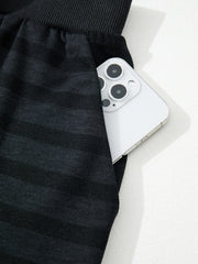 Dark gray striped pajama pants with side pocket holding a smartphone.