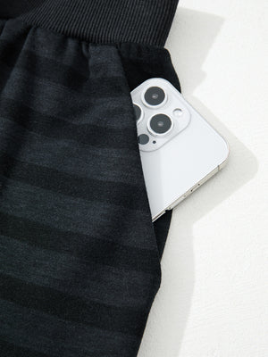 Dark gray striped pajama pants with side pocket holding a smartphone.