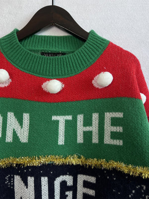 Green acrylic crewneck sweater with white pom-poms and "ON THE NICE" graphic text.