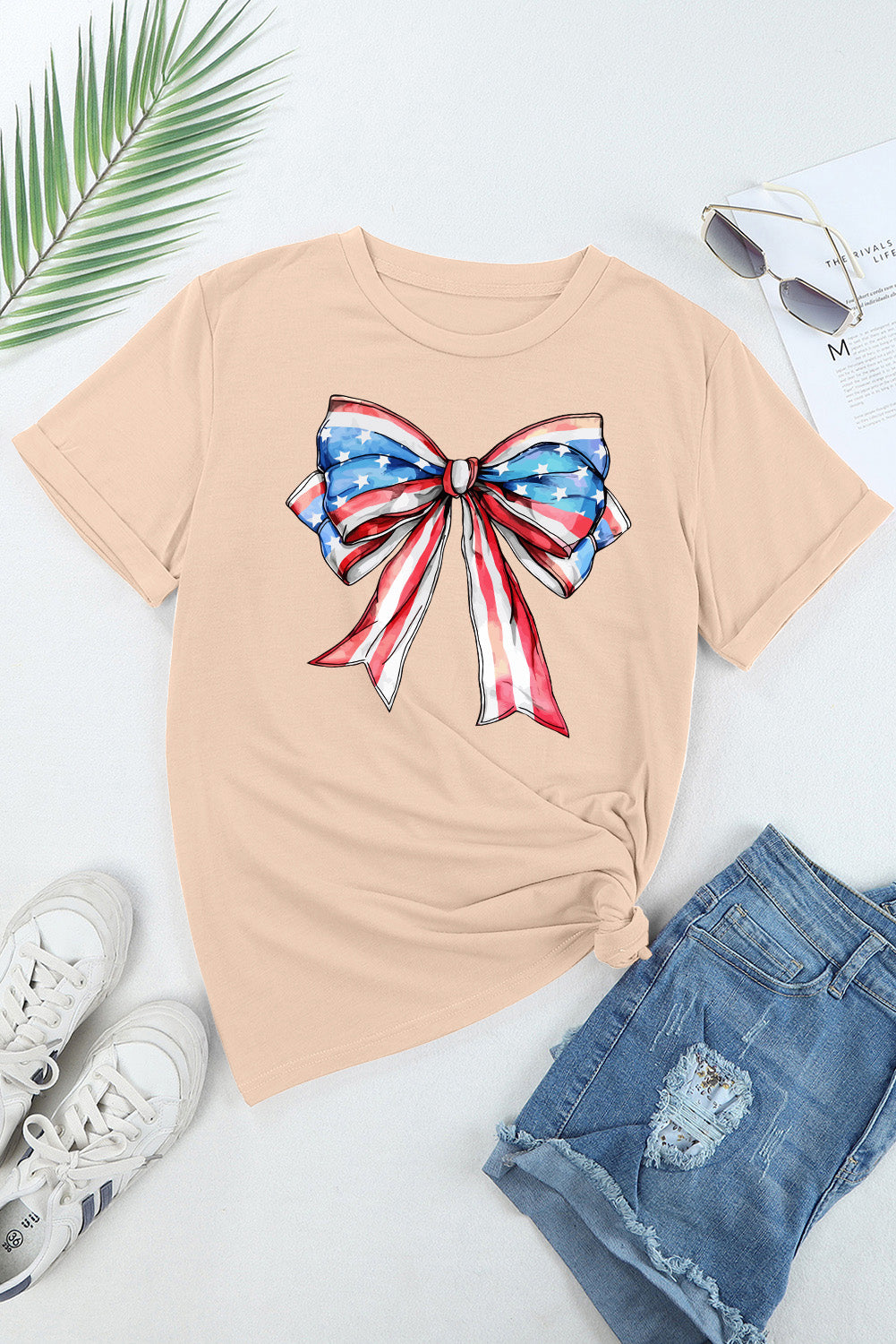 Eggshell t-shirt with a watercolor American flag bow graphic and rolled sleeves.