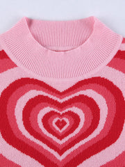 Pink knit tank top with concentric heart intarsia pattern in shades of red and pink.