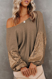 Waffle knit top in tan with sequin sleeves and off-the-shoulder neckline.
