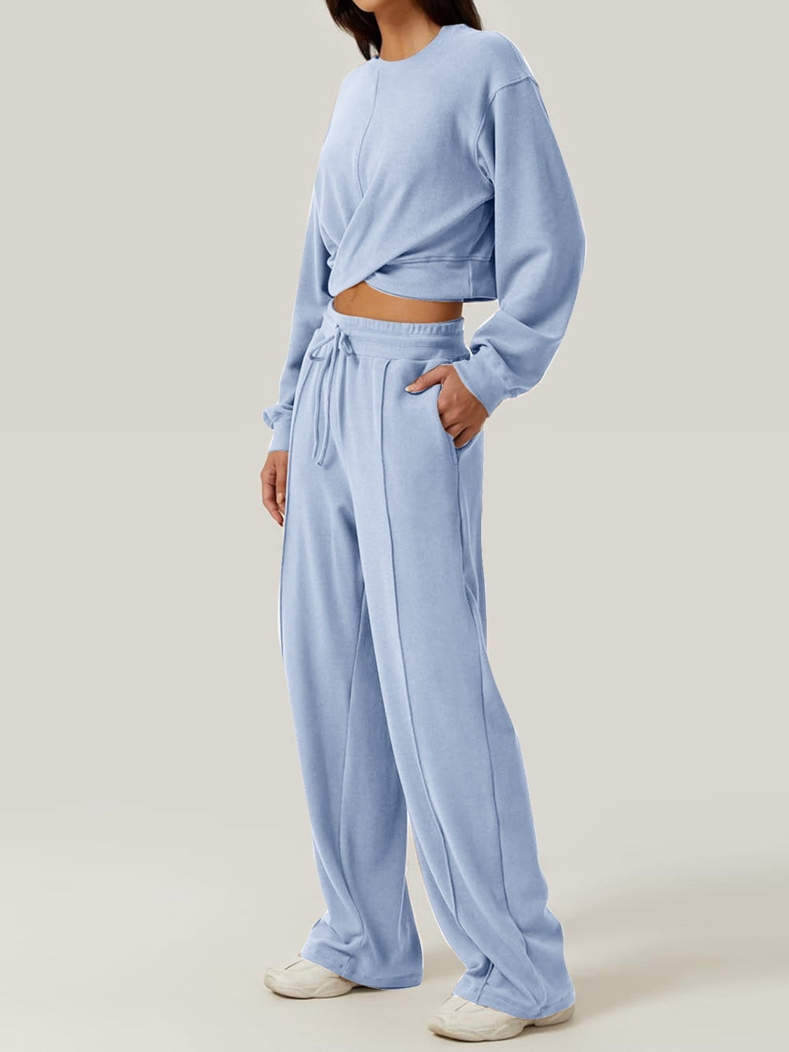 Light blue knit lounge set with a cross-front crop top and wide-leg drawstring pants.