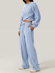 Light blue knit lounge set with a cross-front crop top and wide-leg drawstring pants.