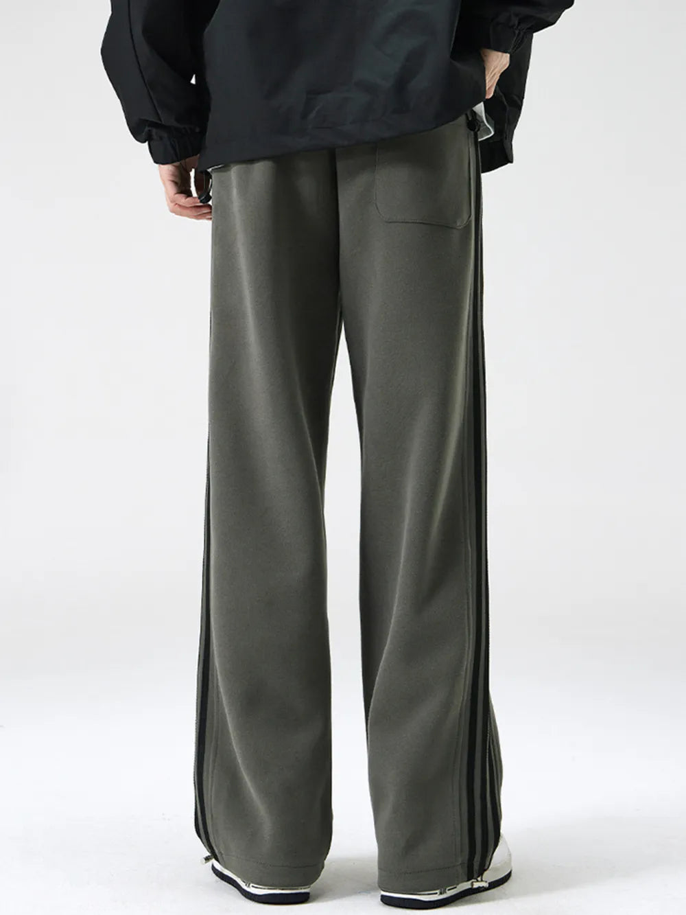 Gray green cotton sweatpants with wide legs and black side stripes.