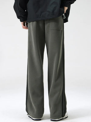 Gray green cotton sweatpants with wide legs and black side stripes.