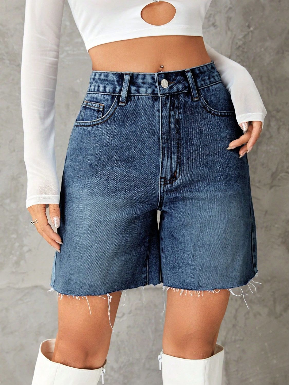 High-waisted denim bermuda shorts in medium blue with frayed hem.