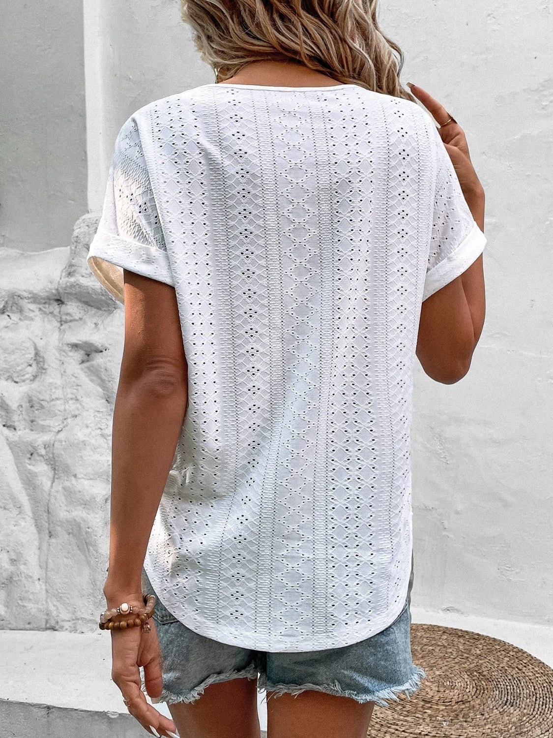 White eyelet v-neck tunic top with short sleeves and a relaxed fit.