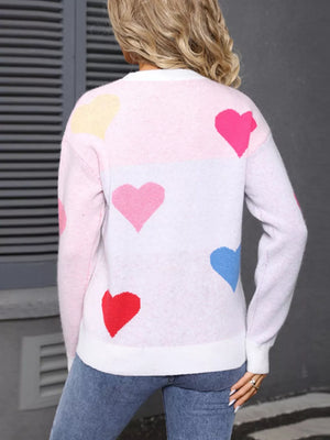 Pink and white acrylic sweater with a heart pattern and round neck.