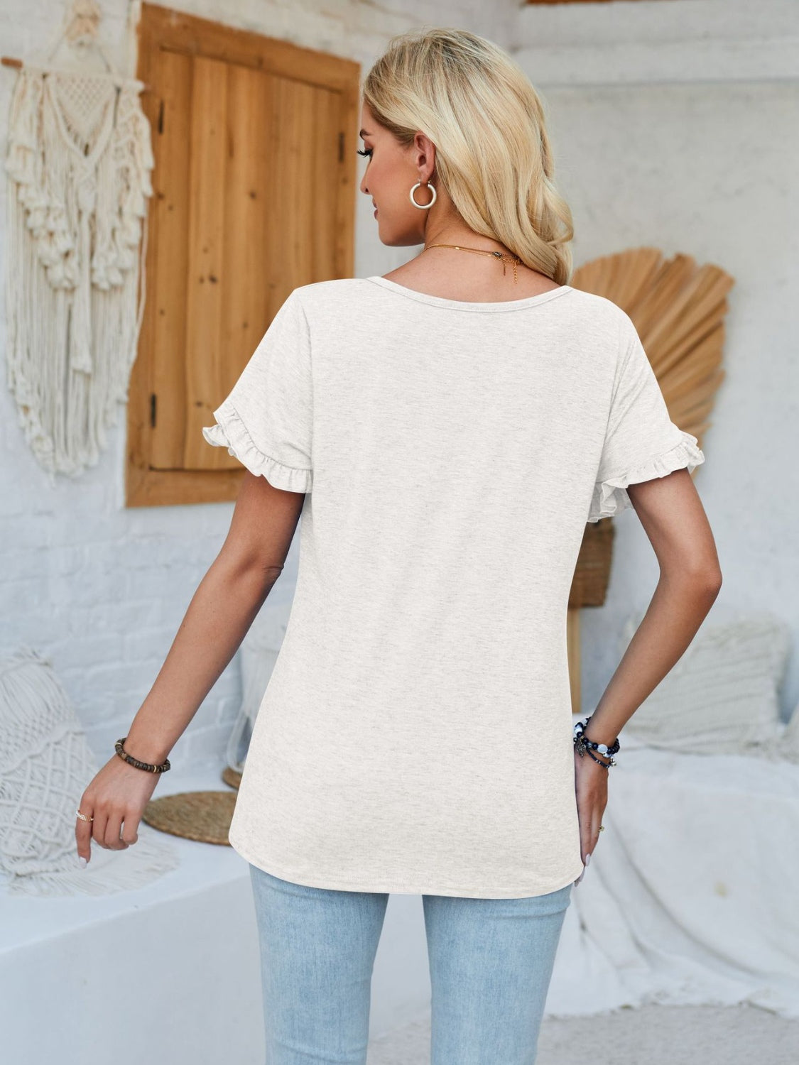 White t-shirt with flutter sleeves and a rounded neckline.