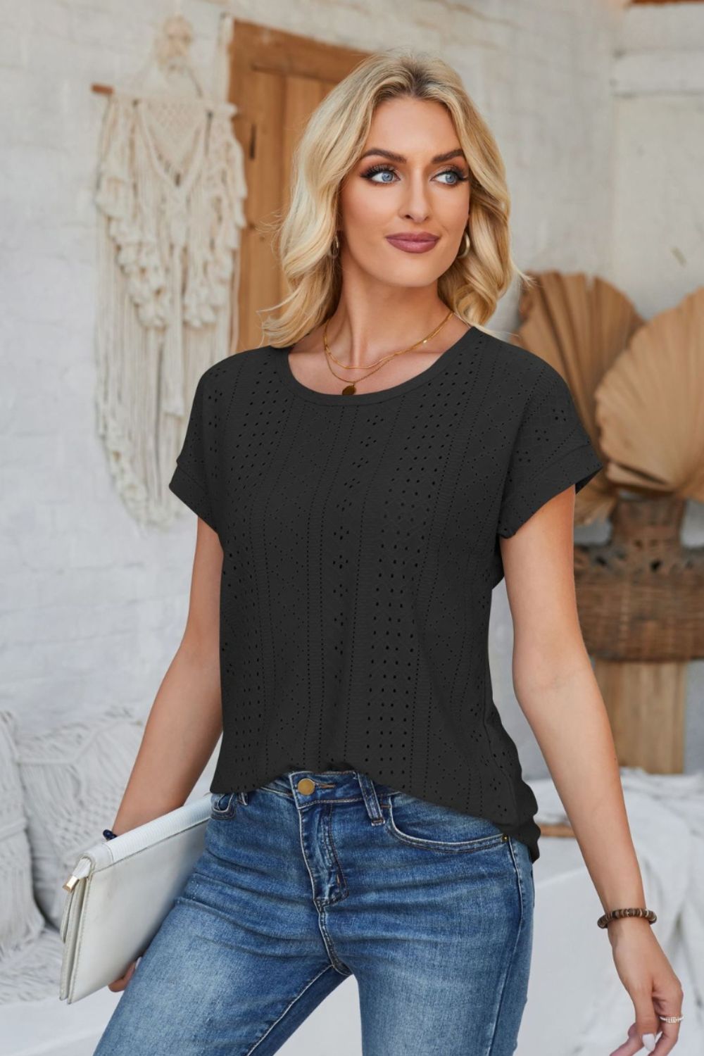 Black perforated eyelet cuffed tee with short sleeves and a round neckline.