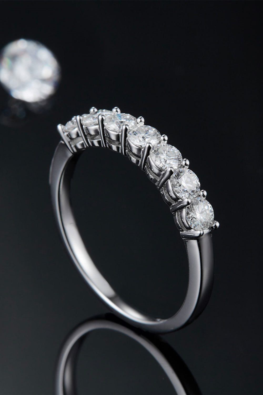 Silver band ring with seven round-cut moissanite stones.