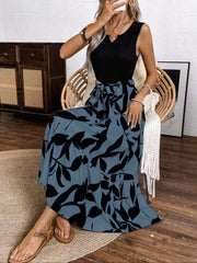 Maxi dress with black floral print on blue-grey fabric, V-neck, sleeveless, and belted waist.