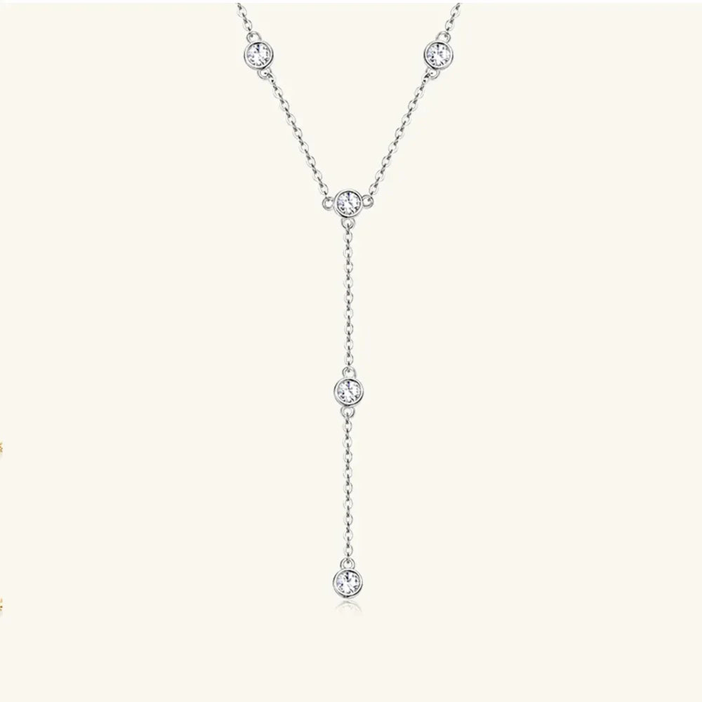 Silver lariat necklace with five bezel-set moissanite stones on a delicate chain.