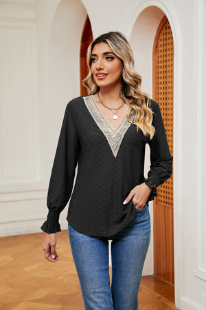 Black lace-trimmed eyelet blouse with V-neck and ruffle cuffs
