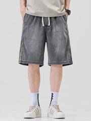 Dark gray denim shorts for him with drawstring waist and loose fit.