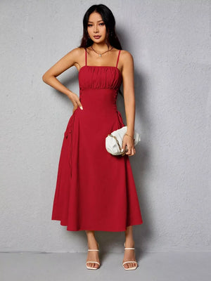 Deep red cami dress with ruched bodice and crisscross lace-up sides, A-line skirt.