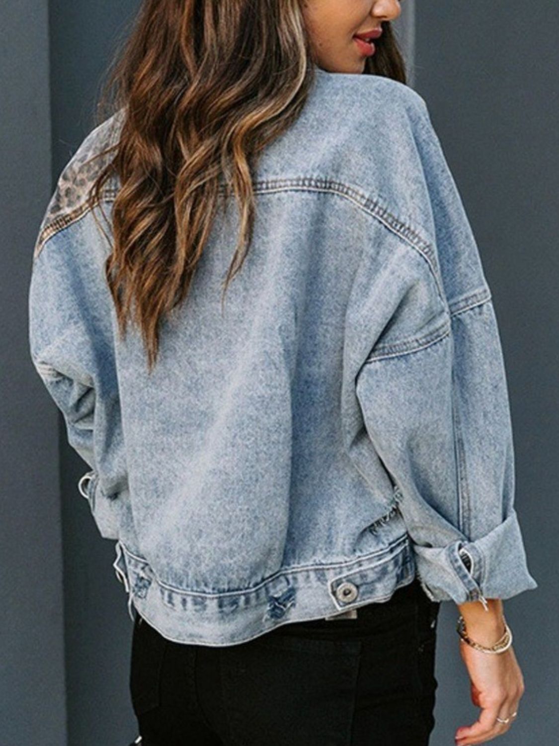 Denim jacket with leopard print panels on shoulders, light wash, relaxed fit.