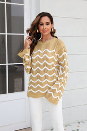 Khaki openwork knit sweater with white wavy stripes and bell sleeves.