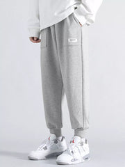 Men's grey relaxed fit joggers with cuffed ankles and a small white logo tag.