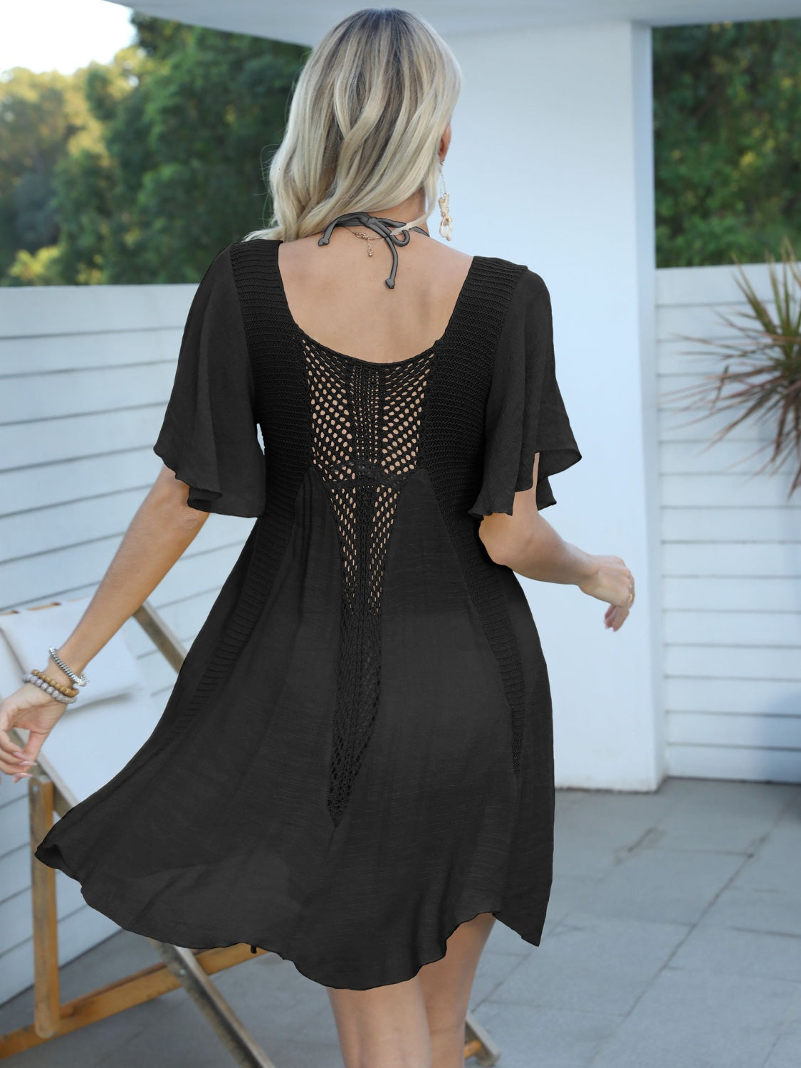 Black crochet inset beach cover-up dress with flutter sleeves and A-line skirt.