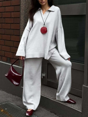 Grey knit polo sweater with button detail and wide-leg pants.