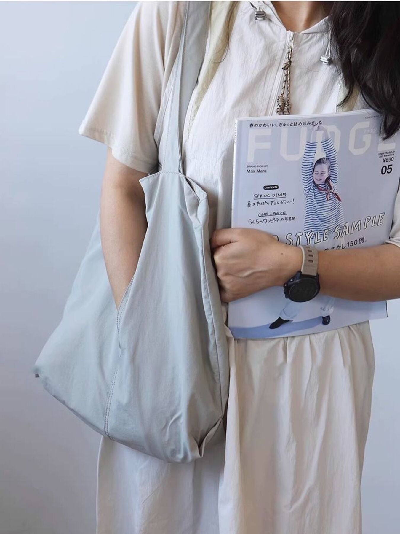 Spacious light blue nylon shoulder bag with exterior slip pocket.