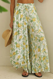 Botanical print palazzo trousers with a drawstring waist and wide legs, featuring a pineapple and floral pattern.