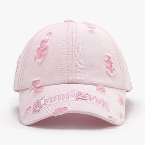 Blush pink distressed baseball cap with embroidered text and frayed details.