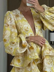 Pastel yellow floral mini dress with ruffled layers and voluminous sleeves.